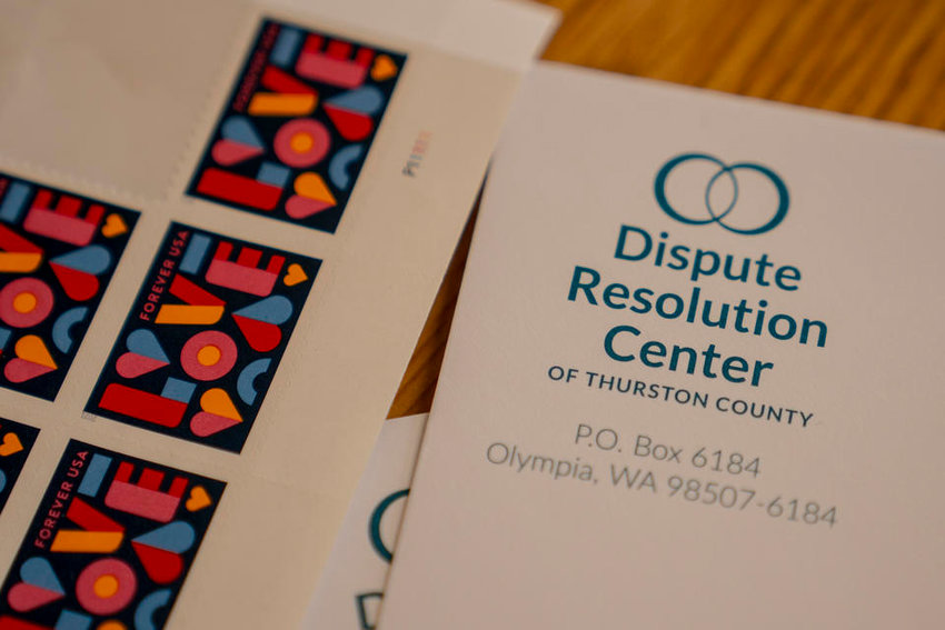 Stamps chosen for their warm and nonthreatening appearance are seen next to an envelope set to be hand addressed to a tenant facing eviction at the Dispute Resolution Center of Thurston County in Olympia, Washington on April 21, 2022. The staff at the center work to broker deals between landlords and tenants facing eviction.