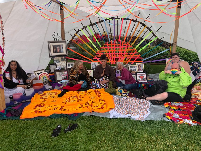 Sitting together in The Zen Den at the Capital City Pride Festival, June 4, 2022, are, l-r: Kenner Reid, a photo of Rikkey Outumuro, who was murdered last 2021, Rikkey&rsquo;s mother Hope Schumacher, Anna Pike, the dog Karma, Rikkey&rsquo;s aunt Brenda Brown, Phillip Galas and Frances Bosteder.