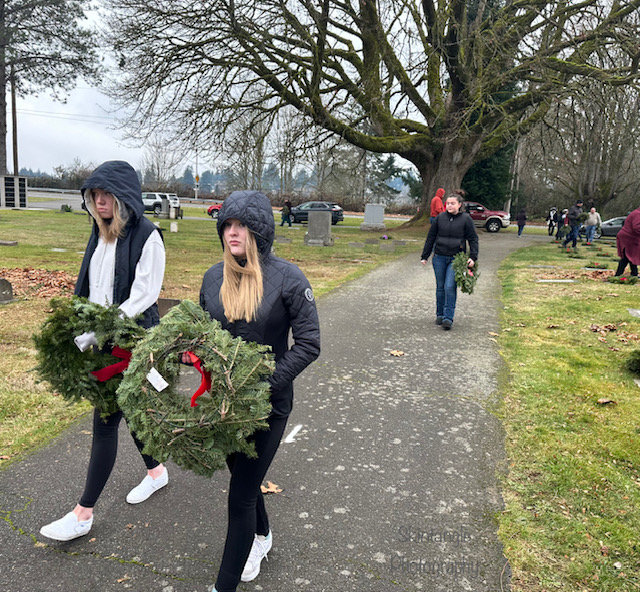 Each volunteer walks to choose a service member&rsquo;s grave for their wreath.