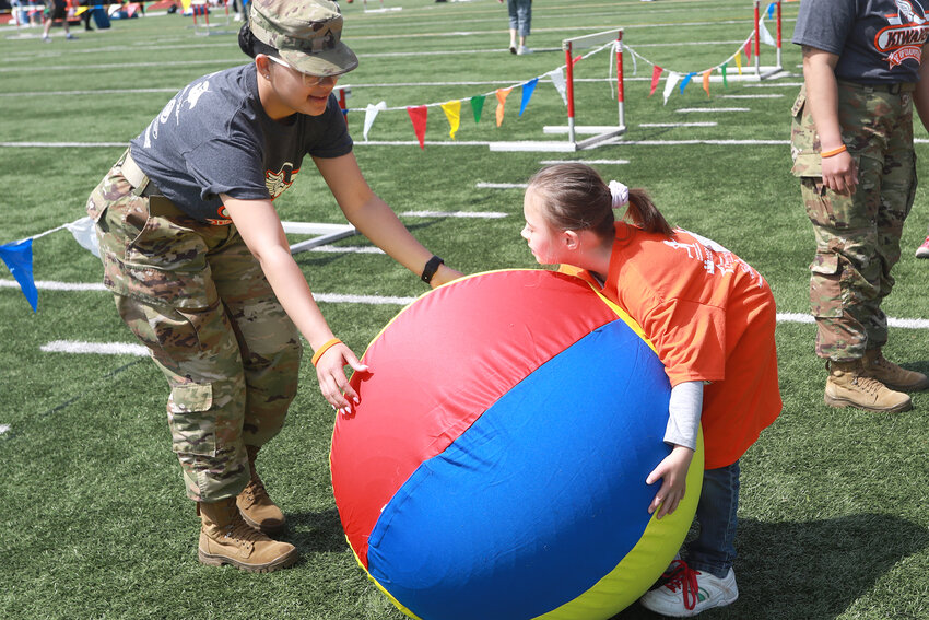 Nashalee Velez (Army Volunteer) with Gracelynn Barnard, Age 5 playing big ball.