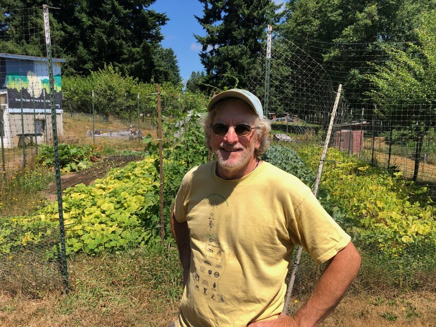 TJ Johnson, founder of Urban Futures Farm, stands before squash and several other crops.