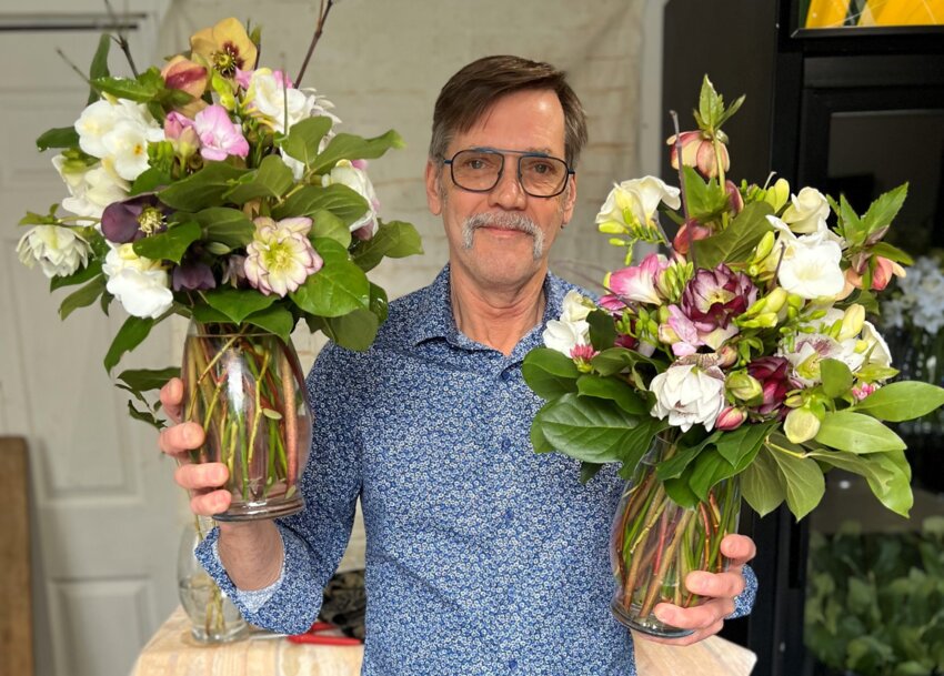 Rick Johnson with arrangements of hellebores, which bloom in late winter and early spring.