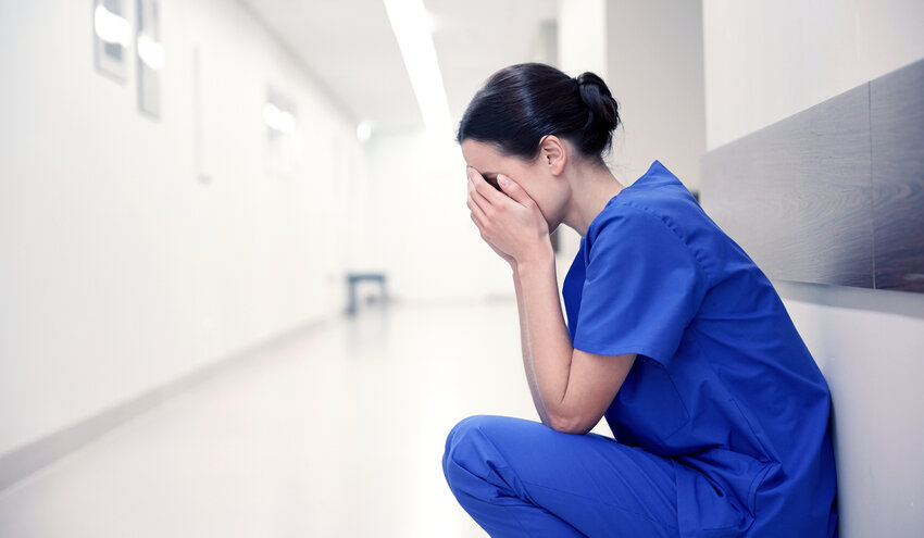 Distressed female nurse in hospital corridor