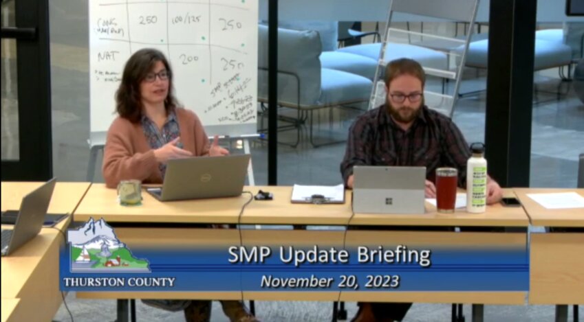 Community Planning Manager Ashley Arai (left) and Senior Planner Andrew Deffobis (right) discuss with the county commissioners whether they want to exclude 100-year floodplains in the county&rsquo;s Shoreline Master Program.