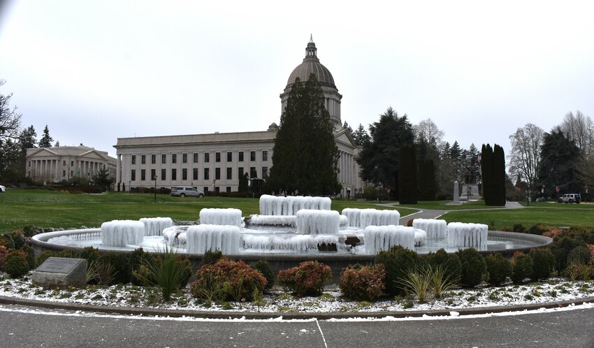 The Capitol Campus fountain, the water frozen in place, with a view of the capital building.