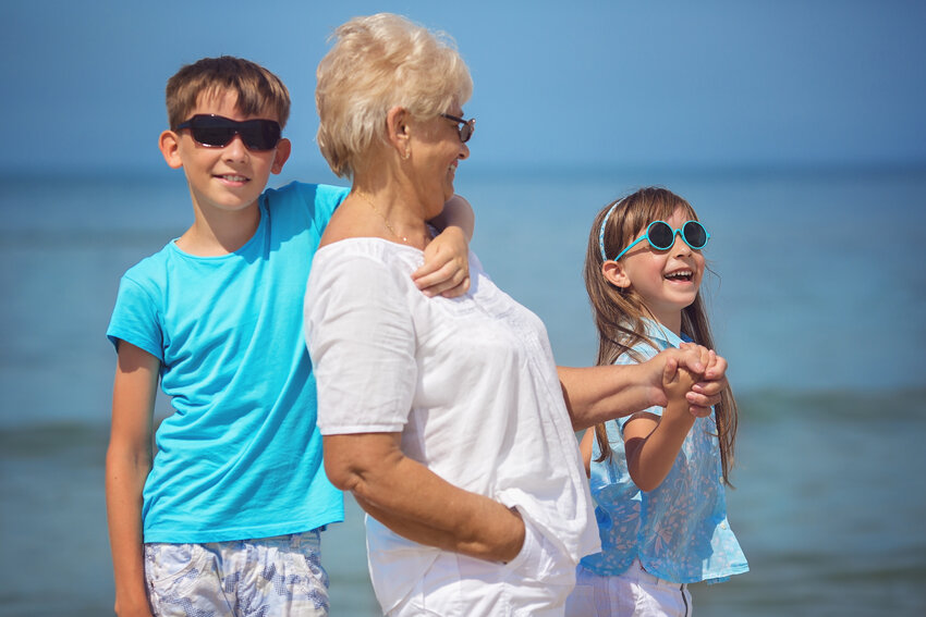 Warm climate portrait of grandmother with her grandchildren having fun on vacation