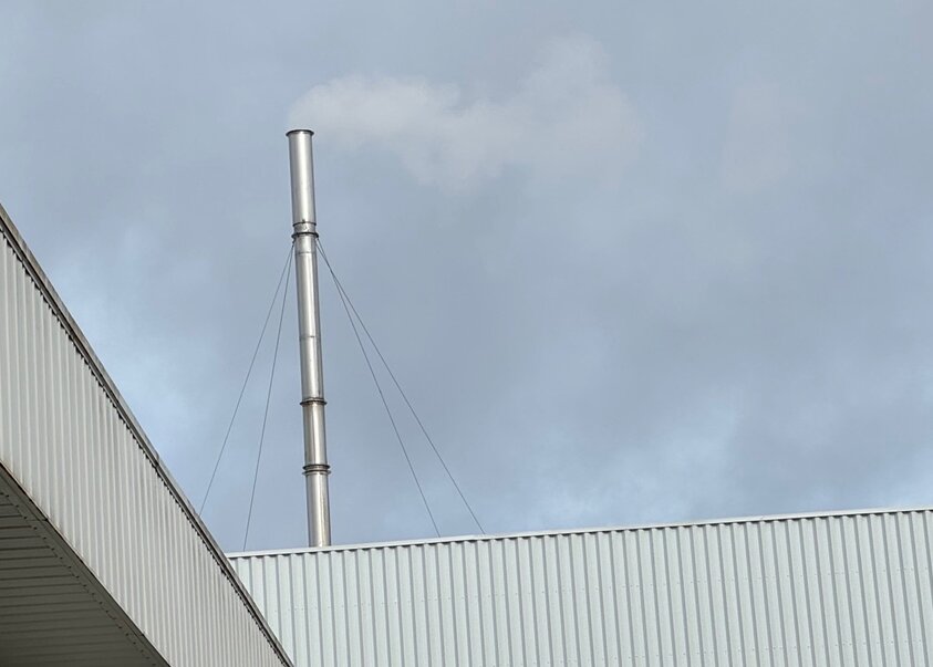 A smokestack emitting smoke, common in many factories.