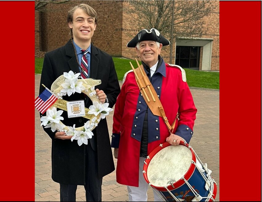 President Julien Bancroft-Connors, Washington State Society Children of the American Colonists with drummer Jan Lemmer. of the Washington State SAR/DAR Fife and Drum Corps in Seattle. Julien holds a wreath from the Children of the American Colonists.