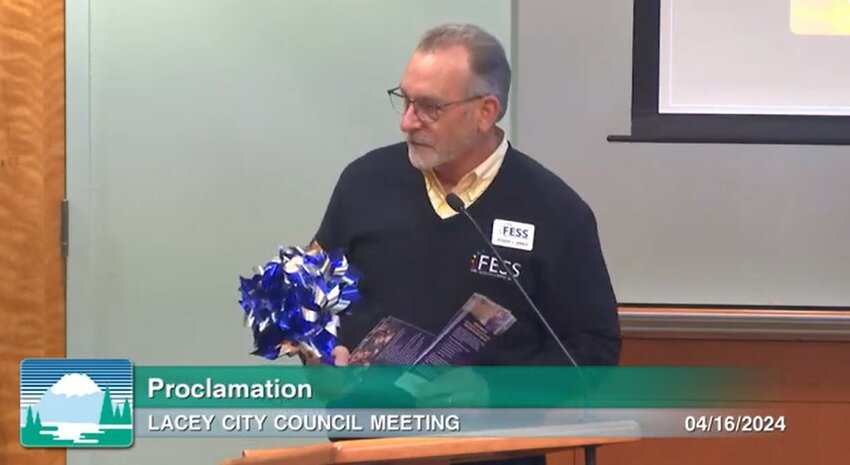 Roger Jones, the Community Engagement Director for Family Education Support Services (FES) distributed blue pinwheels to the Lacey Council on April 16, 2024, symbolizing national solidarity in preventing child abuse.
