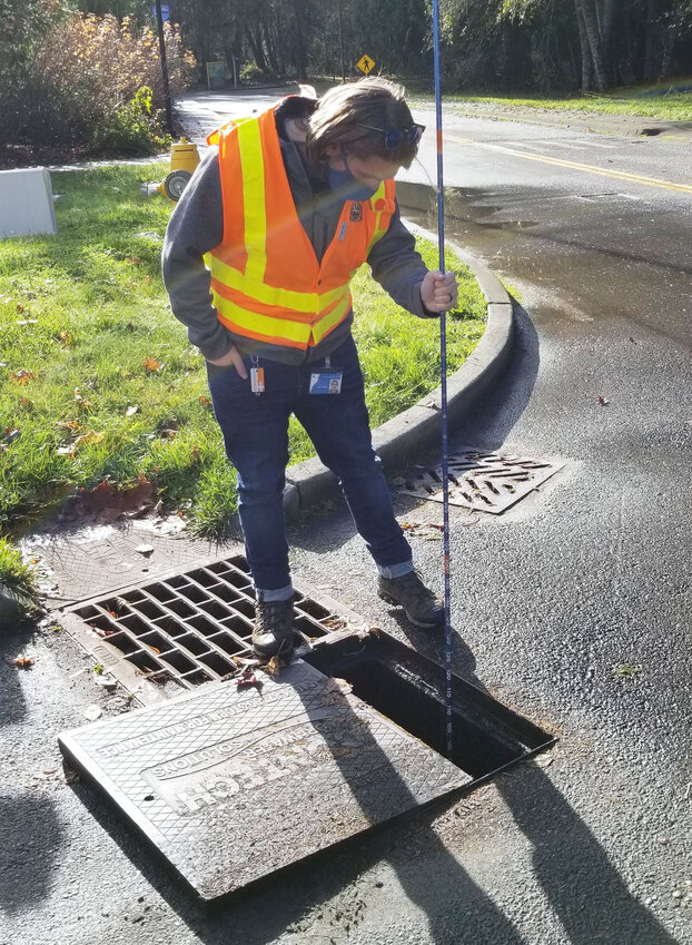 An Olympia Water Resources team member inspects a catch basin.