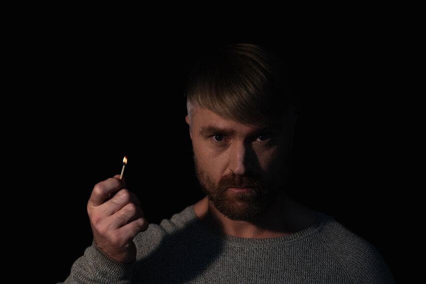 Man lighting a match in the dark