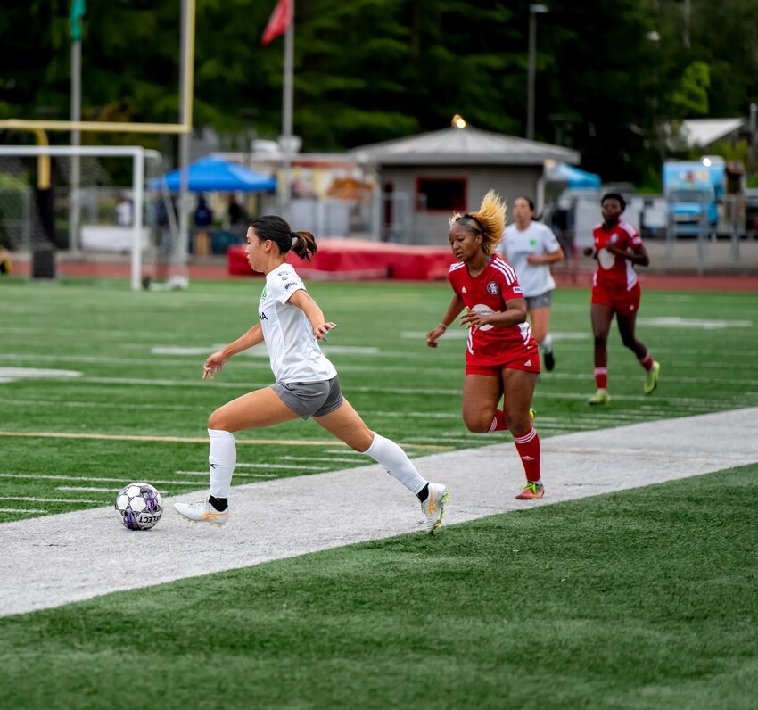 FC Olympia&rsquo;s Yosue Suzuki (in white) dribbles past a defender as she leads the Artesians to a 7-0 win over Capital FC Atletica after her hat trick.