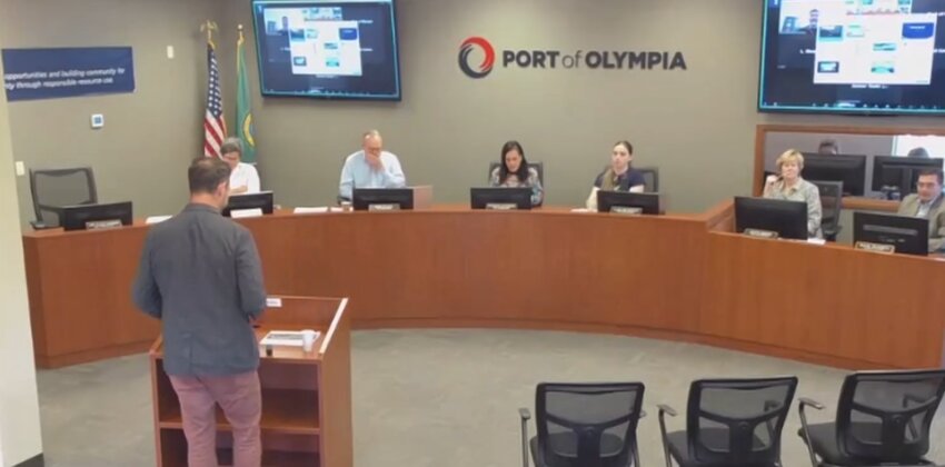 HR Director Ben McDonald (standing on the podium) briefs the Port of Olympia Commission about Dickson Frohlich Phillips Burgess.