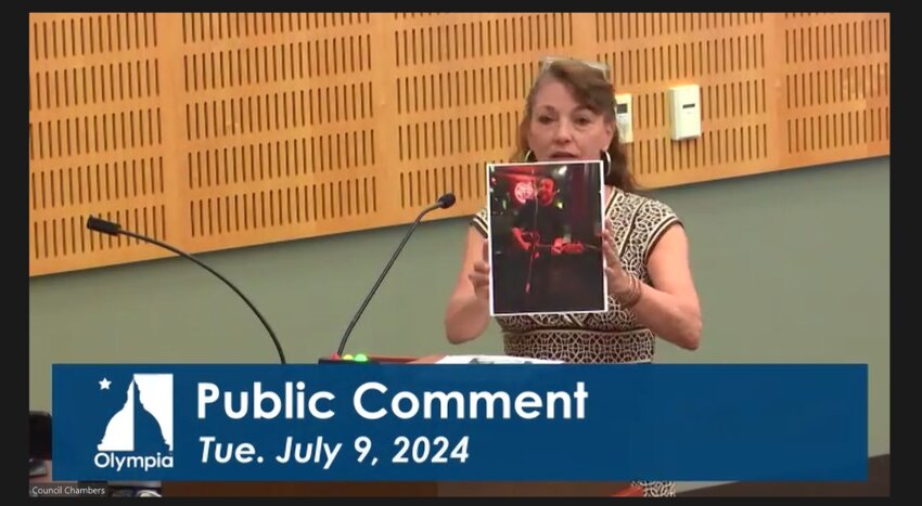 Olympia City Council, Tuesday, July 9, 2024. Shauna Montoya, holding a photo of her late son, Nathaniel Alexander Montoya, recounts how he was killed in April 2023 by individuals living in an RV parked in her neighborhood.
