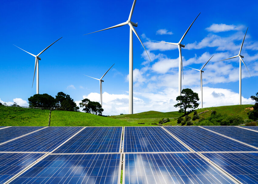 Clean energy concept photo with wind turbines and solar power panels shown.