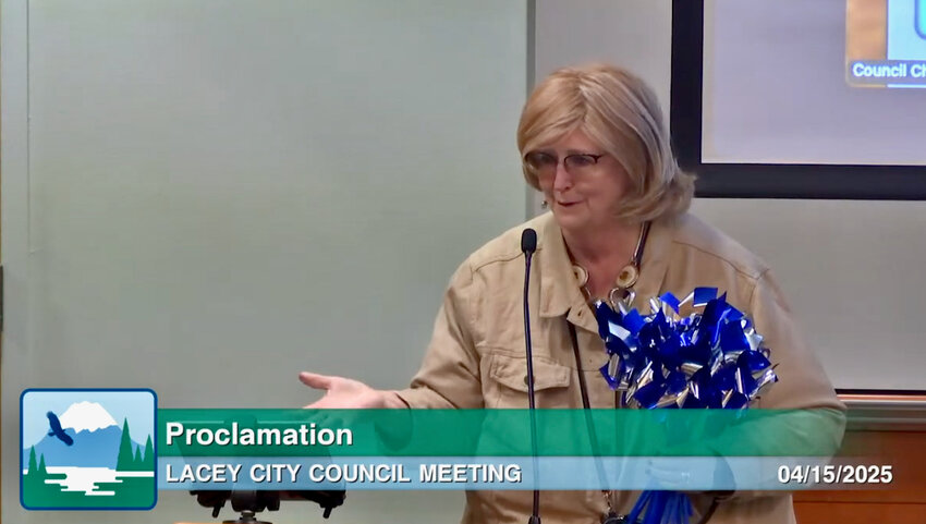 Shelly Willis, Executive Director of Family Education and Support Services, distributed blue pinwheels, a national symbol of child abuse prevention, to council members during the Lacey City Council meeting on Tuesday, April 15, 2025. 