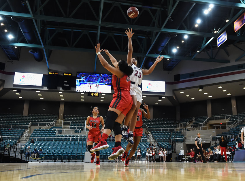 Katy Tx. Feb. 18, 2020: Tompkins' Loghan Johnson (23) goes up for the shot guarded by Fort Bend Travis Amari Grace (20) during a bi-district playoff game between Tompkins Falcons and Fort Bend Travis Tigers at the Merrell Center.  (Photo by Mark Goodman / Katy Times)
