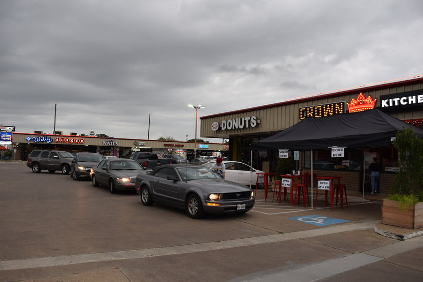 Crown Kitchen diners line up to pick up their food orders. Colburn McClelland, owner of Crown Kitchen and Willy Burger in downtown Katy, said Crown Kitchen is feeding thousands and working to help keep morale up in town.
