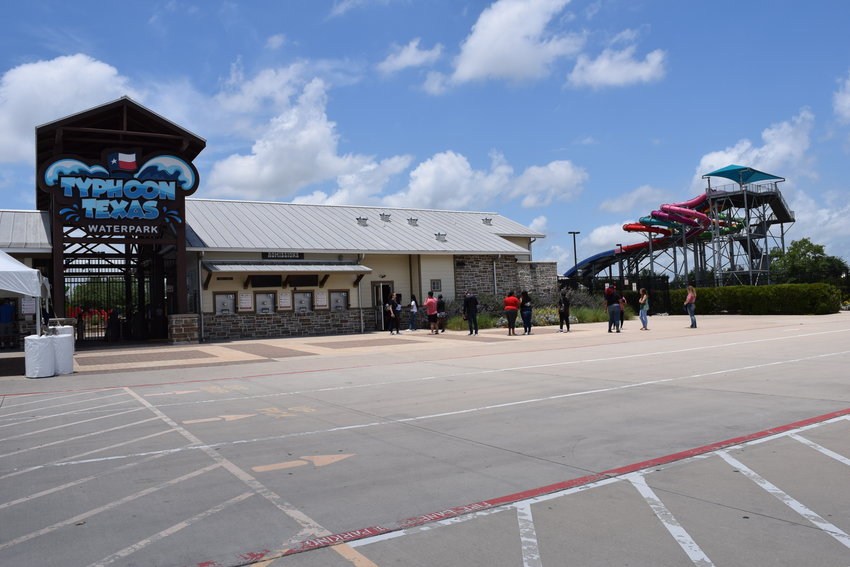 Customers wait in line to purchase tickets Thursday morning so they can get access to Typhoon Texas over the summer season. The local water park, which features several water slides and a lazy river, has instituted safety measures which meet the requirement of Gov. Greg Abbott's current executive order allowing Texas to open back up.