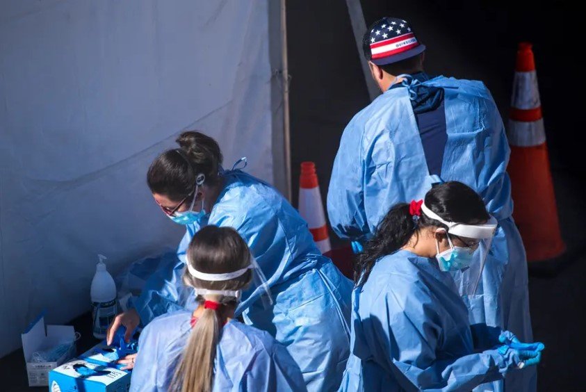Medical personnel put on personal protective equipment at a COVID-19 testing site at the University of Texas at El Paso on Nov. 3. Heading into the Thanksgiving holiday, Texas has set new records for the number of people testing positive for the coronavirus.