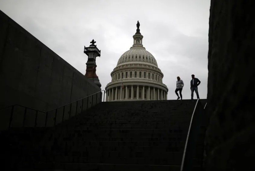 Pedestrians walk along the East Front of the U.S. Capitol Building on Capitol Hill in Washington, U.S. on Dec. 4, 2020.