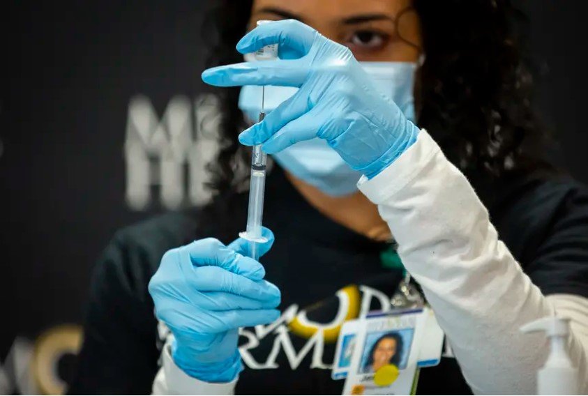 Critical care pharmacist Jennifer Cortes prepares the first Pfizer COVID-19 vaccine at Memorial Hermann Hospital in Houston on Dec. 15, 2020. While all eligible Texans under the first phase of the rollout can now receive the COVID-19 vaccine, doses remain in short supply and many Texans who are desperate to get vaccinated can't get clear answers.