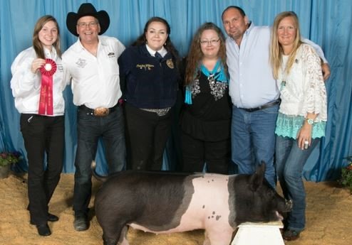 Friendly Li&rsquo;l Spenders members pose with an FFA student and one of the animals the group purchased at the 2020 Katy ISD FFA Livestock Show. The group works to ensure all FFA students are supported by the community and to allow even those who can only contribute a small amount of money to the program to be able to participate through crowd funding.