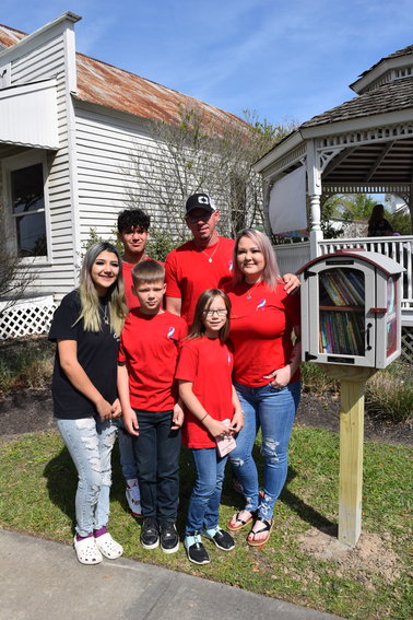 Celia &ldquo;Cici&rdquo; Rico&rsquo;s family poses in front of the newly-placed little library in Cici&rsquo;s honor at Katy Heritage Park. The library is embossed with a small placard that says simply, &ldquo;It&rsquo;s okay to not be okay.&rdquo; Children from left to right: Eleana, Kaden, Kamdyn, Brenlee. Cici&rsquo;s stepfather, Chad Maikranz wears a ball cap behind Cici&rsquo;s Mother, Deana Davidson-Maikranz.