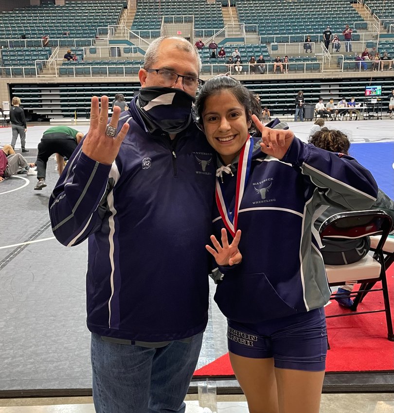 Morton Ranch senior Brittany Cotter poses for a congratulatory photo with coach Mark Balser after Cotter won her fourth district championship at the 9-6A wrestling tournament Saturday, April 10. Cotter is the first Maverick wrestler to win a district title all four years of her high school career.