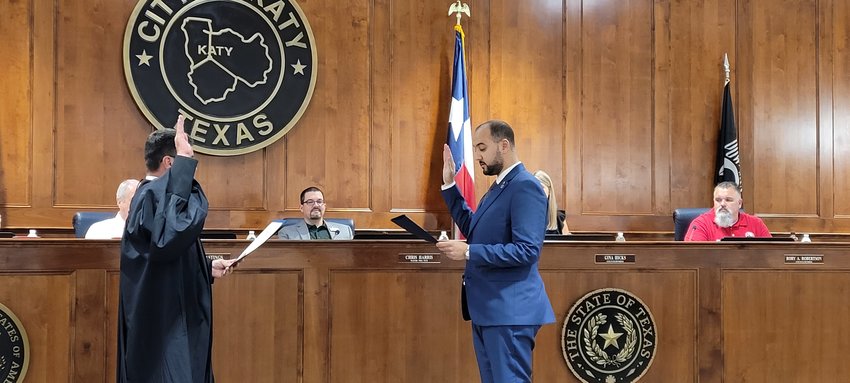 Katy Municipal Court Judge Jeffrey Brashear administers the oath of office to newly-appointed Katy Assistant City Administrator Anas Garfaoui while council members observe during Katy City Council&rsquo;s July 12 meeting. Garfaoui has been with the city for nearly nine years.
