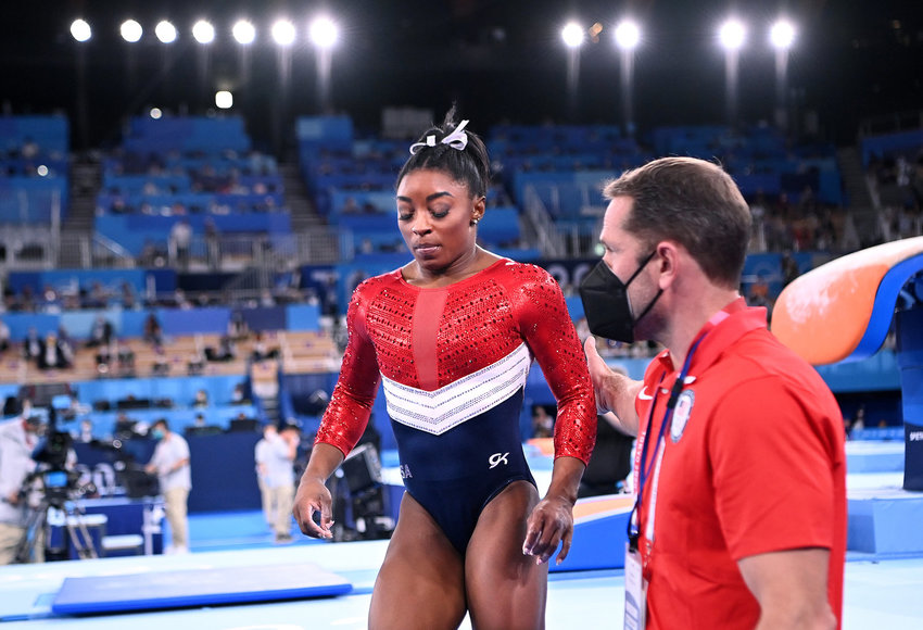 U.S. gymnast Simone Biles is consoled after competing on the vault and withdrawing from competition due to an injury in the women's team final at the 2020 Tokyo Olympics on Tuesday, July 27, 2021 in Tokyo, Japan.