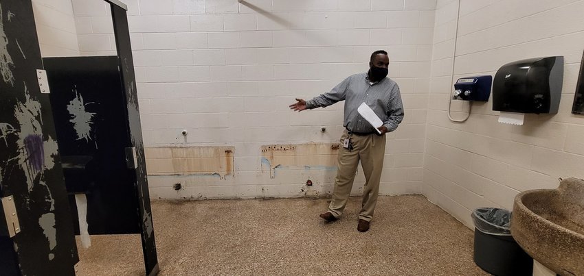 Royal ISD Operations Director Derrick Dabney explains plumbing infrastructure issues at Royal Junior High during an April 28 tour of the facility. The building is aging and needs serious infrastructure improvements to remain safely usable by students, faculty and staff. The urinals in the boys&rsquo; restroom have not been replaced due to plumbing problems under the building&rsquo;s foundation that need to be addressed, Dabney said. RISD officials are hoping a $99.5 million bond will address these issues and allow the district to build two additional campuses to face upcoming growth of the student body.