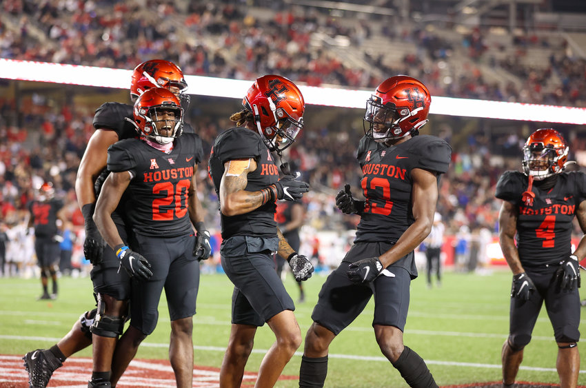 The Houston Cougars offense celebrates after a fourth-quarter touchdown in an NCAA football game between Houston and SMU on October 30, 2021 in Houston, Texas. Houston won 44-37.
