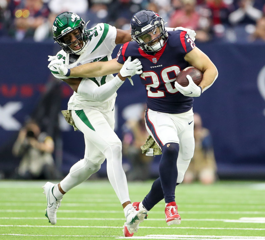 Houston Texans running back Rex Burkhead (28) carries the ball through contact with New York Jets cornerback Bryce Hall (37) during an NFL game between the Houston Texans and the New York Jets on November 28, 2021 in Houston, Texas. The Jets won, 21-14
