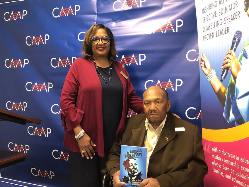 Deborah Owens and her husband, Rev. Bill Owens, pose with a copy of their 2019 book, &quot;A Dream Derailed.&quot;