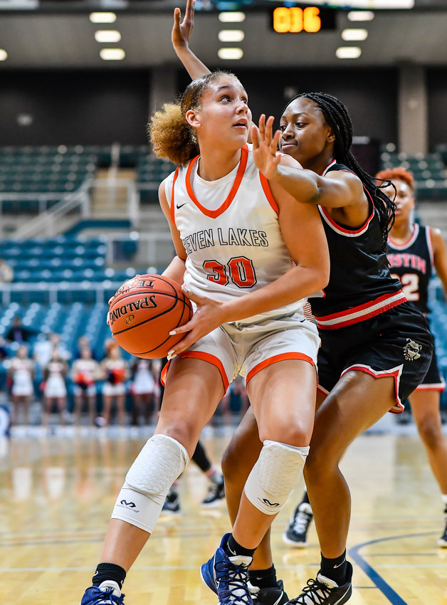 Katy Tx. Feb 22, 2022:  Seven Lakes Justice Carlton #30 drives to the basket guarded by Fort Bend Austins Brittney Adeck #15 during the Regional Quarterfinal playoff game, Seven Lakes vs Fort Bend Austin at the Merrell Center. (Photo by Mark Goodman / Katy Times)