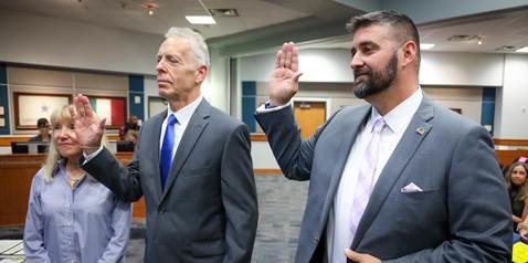 Victor Perez and Lance Redmon take their oaths of office as trustees Monday.