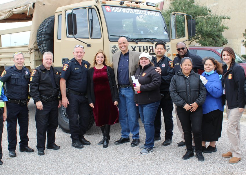 Harris County Pct. 5 Constable Ted Heap, third from left, Rosemary Jackson, fourth from left, and Aaron Jackson pose with others in front of a rescue truck the Jacksons purchased&mdash;but hope never to use&mdash;for hurricane victim rescue operations.