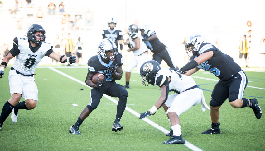 Paetow&rsquo;s Derrick Johnson evades a defender during Friday&rsquo;s game against Conroe at Legacy Stadium.