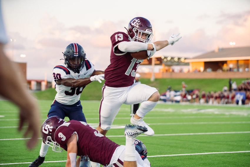 Cinco Ranch&rsquo;s Fischer Reed hurdles over a teammate and fights for extra yardage during Friday&rsquo;s game between Cinco Ranch and Tompkins at Rhodes Stadium.
