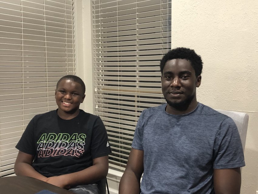 Julian and Jaylan Gray share their story of perseverance. They are sitting at their mother&rsquo;s table, which was restored, along with their house, after flood and winter storm damage.