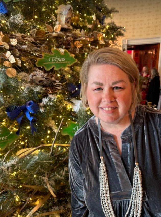 Katy ISD teacher Elizabeth Harden poses in front of one of the White House Christmas trees. The Texas ornament can be seen behind Harden.