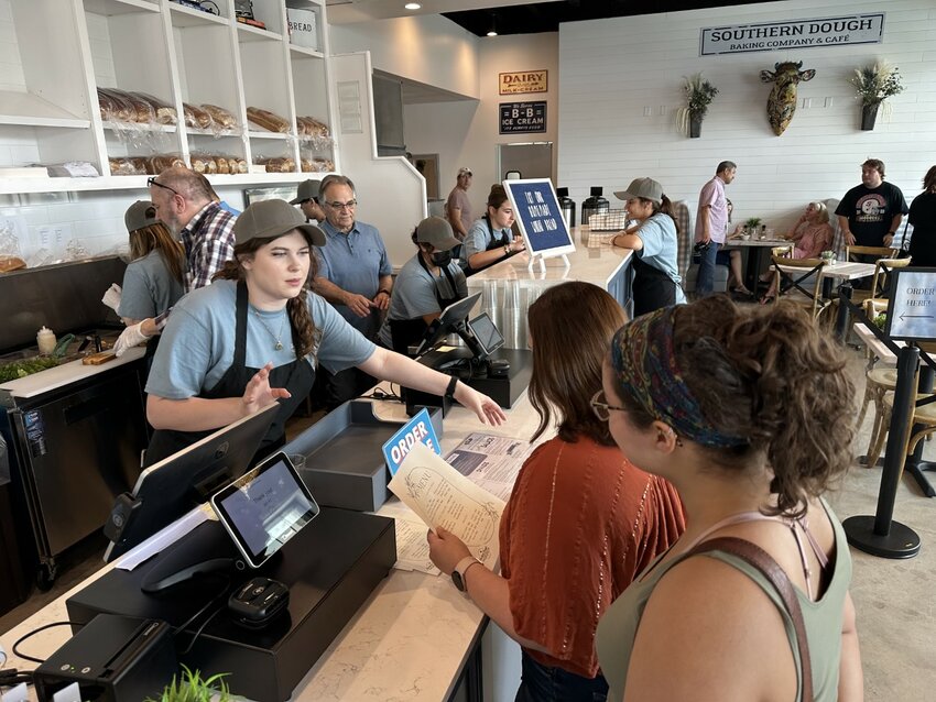 Belle Adams, left, waits on Maddison McKinnon, center, and Charlize Kendrick during a soft opening at the Southern Dough Baking Co., 908 Ave. B. The restaurant held a &ldquo;soft opening&rdquo; on Katy Market Day, thus ensuring a larger crowd to try its menu.