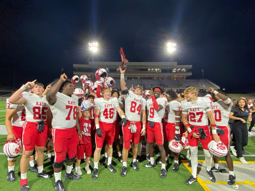 Luke Carter lifts the district championship trophy after Katy beat Taylor.