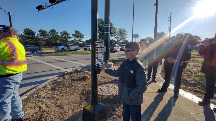 Bennett Smith, a fifth-grader at Robertson Elementary School in Cane Island, pushes the button to activate the &ldquo;walk&rdquo; signal at the newly-operational traffic signal at Franz Road and Cane Island Parkway. Bennett is the son of City of Katy Councilmember Dan Smith.