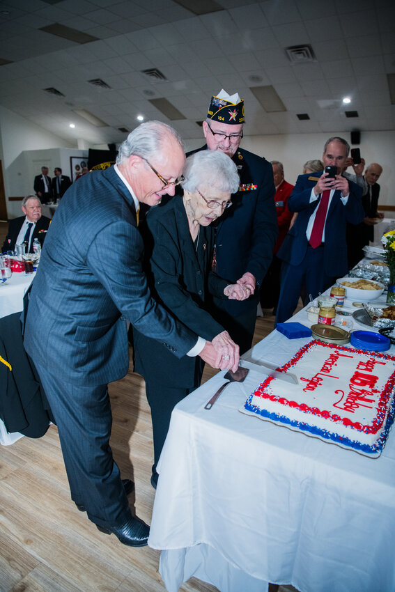 The American Legion celebrated its 105th anniversary with a special dinner on Friday, March 15th hosted by local Post 164 at the Elks Lodge, 1050 Katy Fort Bend Road. Cutting the birthday cake are (left to right) Post Commander Peter Betura, 105-year-old World War II Army veteran Thelma Williams and American Legion District 22 Commander James McGuire. Snapping a photo of the cake is State Representative Michael Schofield, who also spoke at the event.