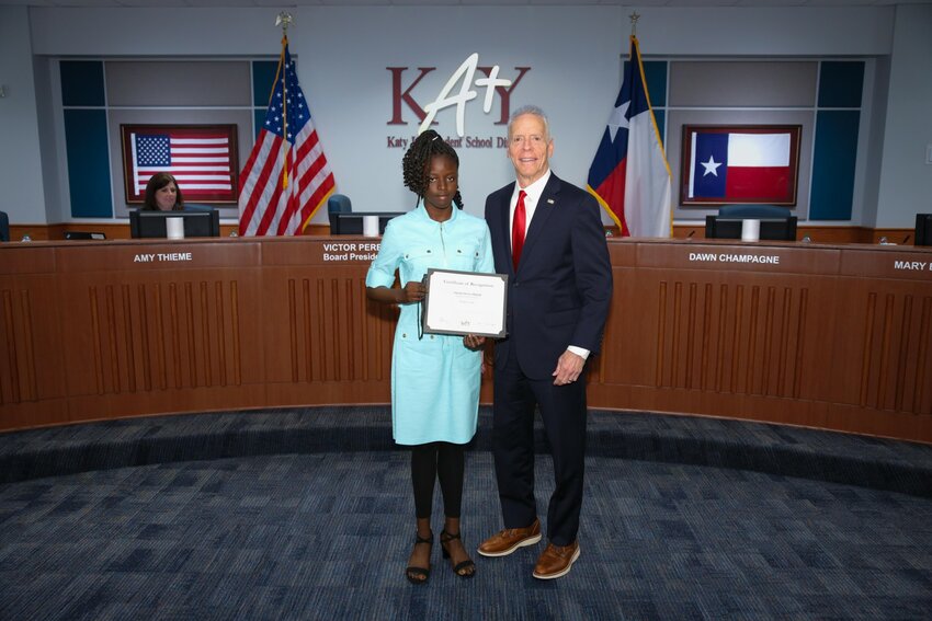 Anjolaoluwa Olajide, a fifth-grade student from Youngblood Elementary, (left) received a certificate of recognition from Katy ISD School Board President Victor Perez after leading the pledges of allegiance at the April 22 school board meeting.