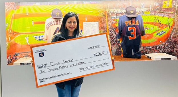 Jordan High School STEM teacher Divya Kaushal shows the mock check for $2000.00 which she received from the Houston Astros Foundation at an August 31 game at Minute Maid Park in Houston.