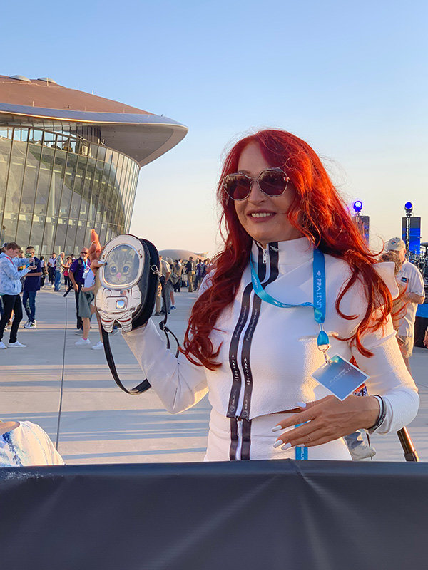 Founding member of the future astronauts slated to go to space, Lina Boroczina, wears an outfit she created using lanyards and materials from previous Virgin Galactic events. She holds her “catstronaut” handbag.