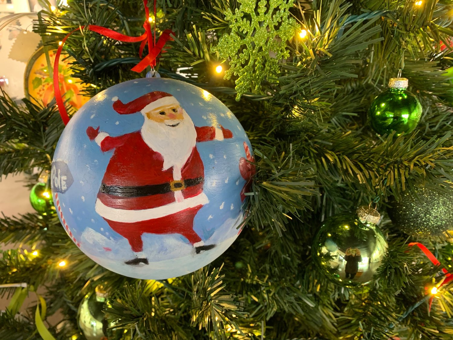 A Santa ornament at the Mas Art Gallery welcomes the holiday with joy and open arms.
